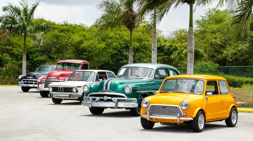 Une rangée de voitures anciennes garées sur un parking