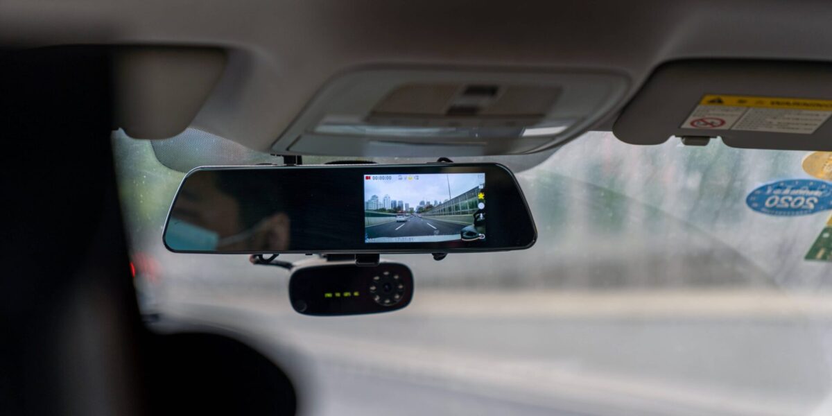 Vue d'une dashcam installée sur un pare-brise de voiture, illustrant la conduite en toute sécurité