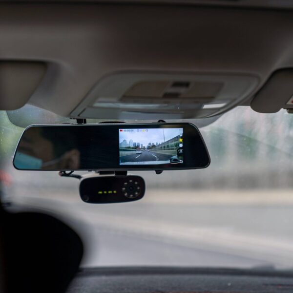 Vue d'une dashcam installée sur un pare-brise de voiture, illustrant la conduite en toute sécurité
