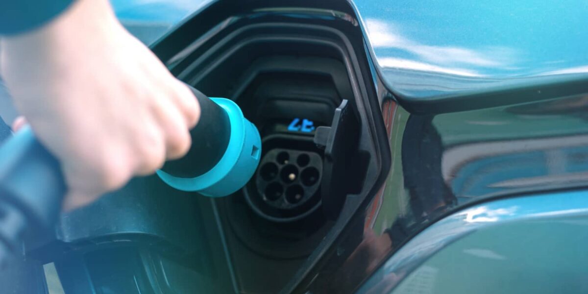 homme branchant un chargeur sur une borne pour voiture électrique 1