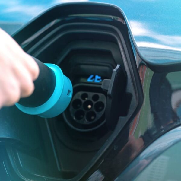 homme branchant un chargeur sur une borne pour voiture électrique 1